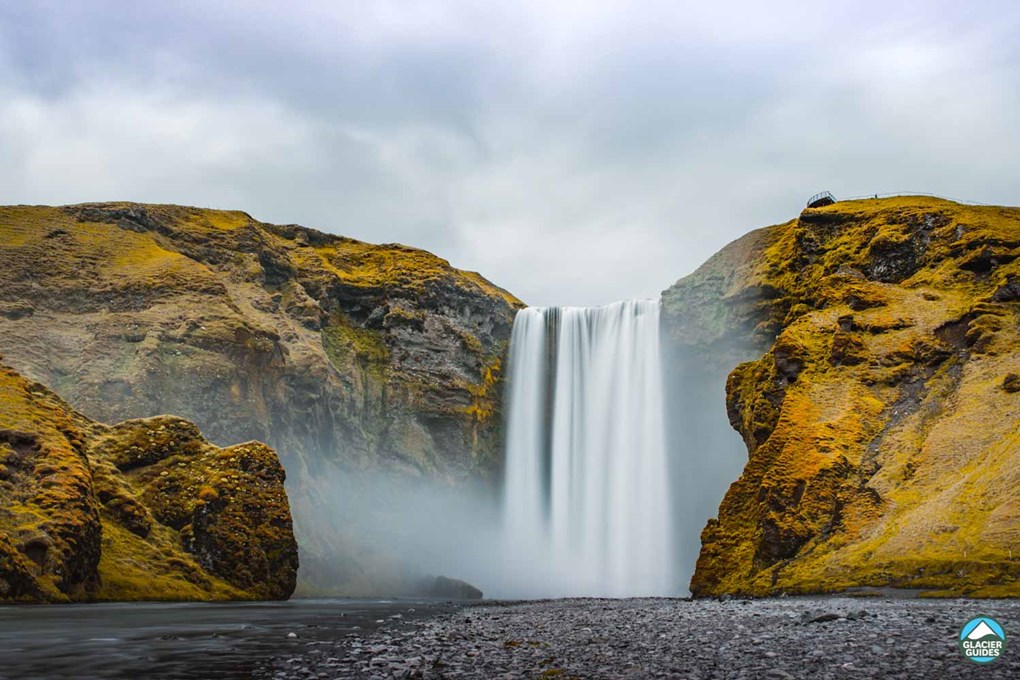 Black Sand And Skogafoss Waterfall In Iceland